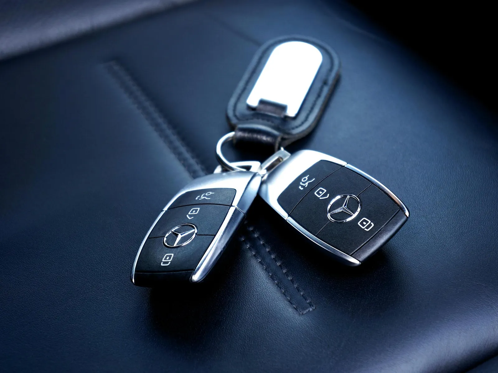 Dos llaves de coche Mercedes-Benz con mando sobre un asiento de piel
